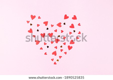 Heart shape made of red hearts and sequins on a pink background greeting card for valentine's day