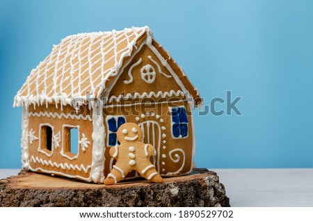 Christmas gingerbread house and man on blue background