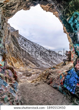 Photographer under natural stone arch formation in scenic Provo canyon Utah