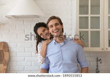 Portrait of happy millennial Caucasian couple renters hug cuddle pose in new home together. Smiling young 20s man and woman spouses tenants have fun enjoy cozy morning in own house. Rent concept. Royalty-Free Stock Photo #1890555853