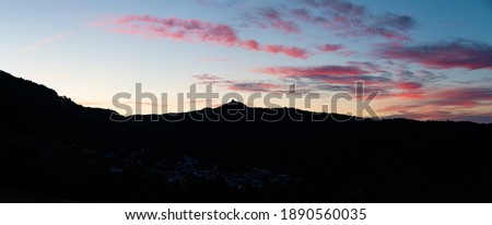 Dawn behind a mountain with a castle