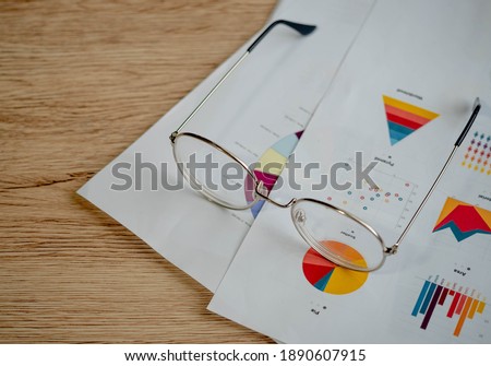 The Picture of Business Planning Concept. Economic analysis concept. Graph paper and glasses are placed on the wooden table.