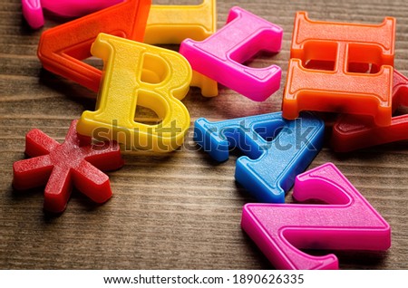 Plastic Letters of English Alphabet on Wood board background