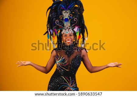 Brazilian afro woman posing in samba costume over yellow background with free space 
