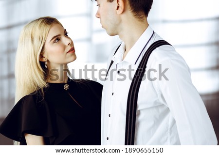Young couple of businessman and woman are standing in a modern office. Portrait of successful business people
