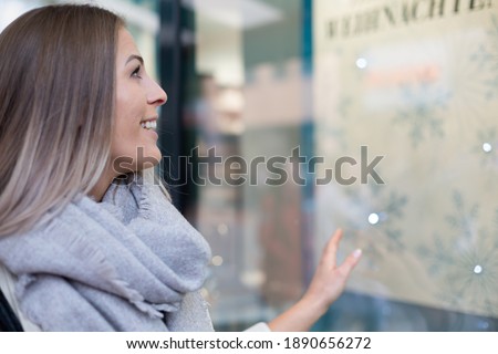 Happy woman is shopping with bag enjoying in shopping on store window. Consumerism, shopping, lifestyle concept
