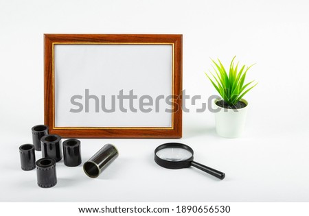 Blank photo frame, photographic film on the table on a white background. Make up.