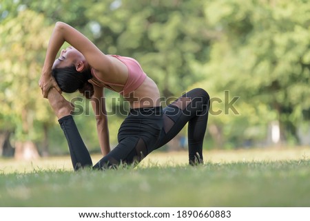 Asian woman doing yoga exercise and relax with sportswear in park, sport and healthy lifestyle concept