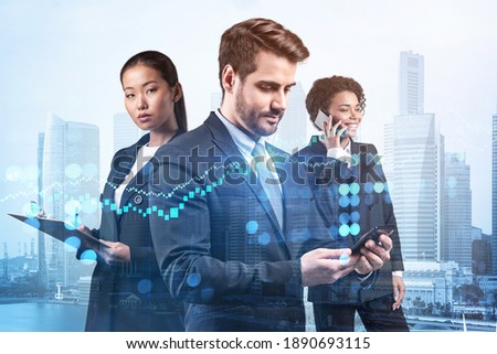 Group of business colleagues working on new venture capital and hi-tech start up and try to forecast risks and estimate prospective earning growth. Hologram chart on Singapore background.