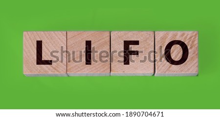 LIFO Last in, first out word on wooden cubes on blue background. Accounting, Business Concept image.