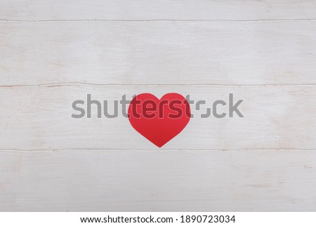 Red heart. For the holiday and Valentine's Day. On a white wooden background. Minimalism. For the design and writing of text.