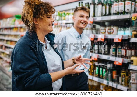 Supermarket store manager giving training to young worker. Grocery store manager explaining the way to work to a new male employee. Royalty-Free Stock Photo #1890726460