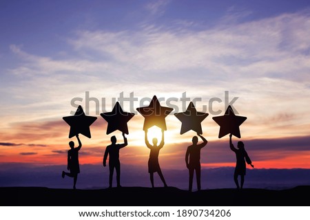 Silhouette peoples holding star with colorful dramatic sky at sunset. Service rating, satisfaction concept