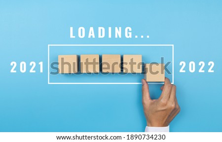 Hand putting wood cube for countdown to 2022. Loading year 2021 to 2022. Start concept Royalty-Free Stock Photo #1890734230