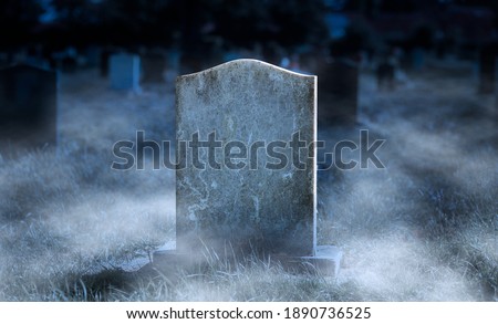 Creepy blank gravestone in graveyard at night with low spooky fog Royalty-Free Stock Photo #1890736525