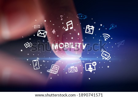 Finger touching tablet with drawn social media icons and MOBILITY inscription, social networking concept