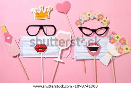 Paper funny girls consisting of sunglasses, wreath, flower crown, lips with a medical mask, a glass of champagne, bottle, heart and a bouquet on the pink background. Quarantine party. Funny fashion.