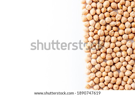 Pile of chickpeas arranged to the right of the image on a white background. vegan food and nutrition.