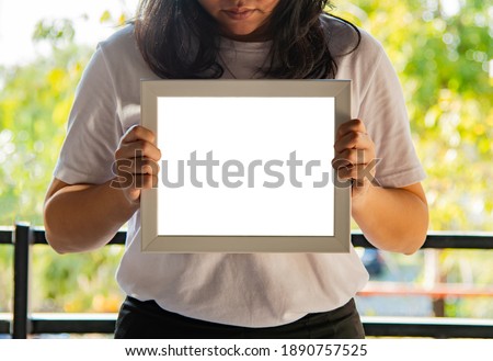 woman holding an empty frame and copy space