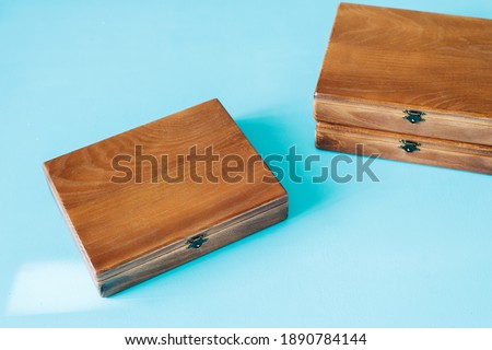 Wooden gift boxes on blue background. Handmade  boxes for keeping pictures, top view, flat lay.