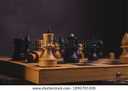 King Chess Piece in the center of the composition to International Chess Day against blurred other Chess pieces.