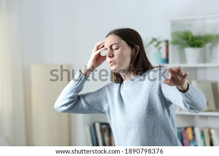 Dizzy woman suffering vertigo attack standing in the living room at home Royalty-Free Stock Photo #1890798376