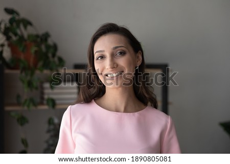 Close up profile picture of smiling indian Arabic woman renter or tenant pose in own apartment. Headshot portrait of happy 20s middle eastern female feel satisfied excited indoors in new home.