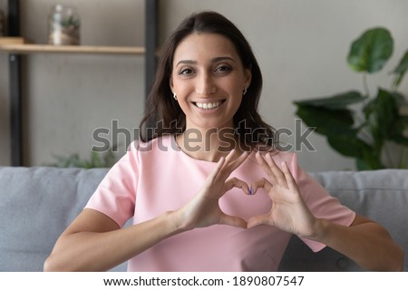 Close up portrait of smiling young indian Arabic woman show heart love hand gesture support sick. Happy millennial middle eastern female feel supportive, show empathy and care. Volunteer concept. Royalty-Free Stock Photo #1890807547