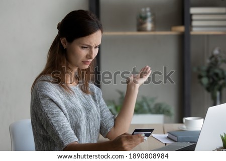 Unhappy millennial woman frustrated by unsuccessful payment with credit card shopping online on computer. Confused young Caucasian woman have problems with bank account paying on internet.
