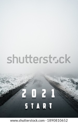 Road with dense fog and snow on the sides with start 2021