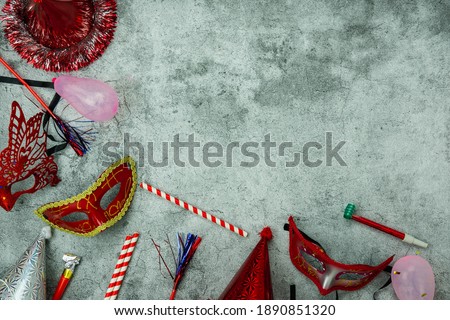 Table top view aerial image of beautiful colorful carnival festival background.Flat lay accessory object the several mask decor confetti on modern grey cement at home office desk studio.copy space.