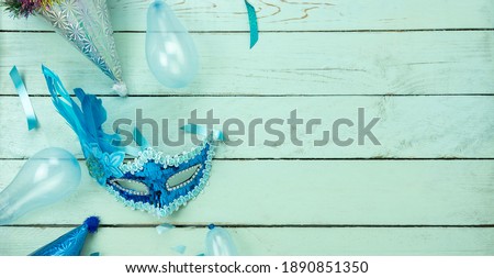 Table top view aerial image of beautiful colorful carnival festival background.Flat lay accessory object the several mask  decor confetti on modern blue wooden at home office desk studio.copy space.