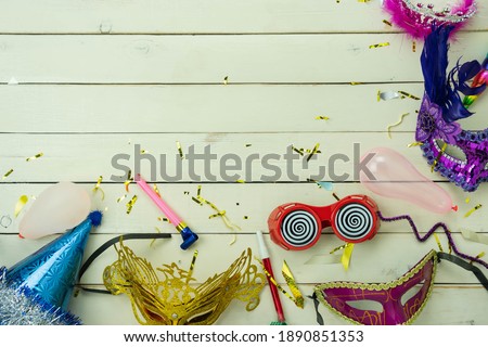 Table top view aerial image of beautiful colorful carnival festival background.Flat lay accessory object the several mask  decor confetti on modern white wooden at home office desk studio.copy space.