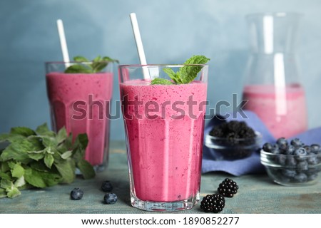 Tasty fresh milk shake with berries on light blue wooden table Royalty-Free Stock Photo #1890852277