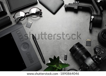 Camera and video production equipment on grey stone background, flat lay. Space for text