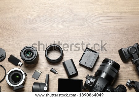 Flat lay composition with camera and video production equipment on wooden background. Space for text
