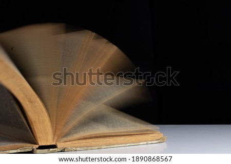 defocused photo of an ancient open book on black background