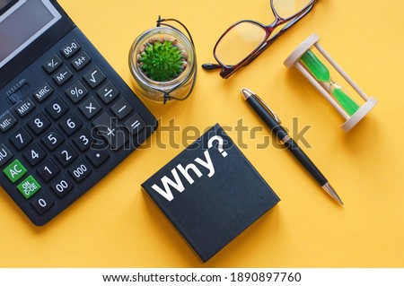 text why is written on the black box of the calculator on the yellow table, stock photo