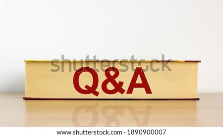 Questions and answers symbol. Book with word 'Q and A, questions and answers' on beautiful wooden table, white background. Business and questions and answers concept. Copy space.