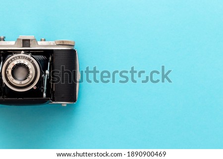 Old retro camera seen from top view in flat lay against blue pastel showing nostalgic feeling. Royalty-Free Stock Photo #1890900469