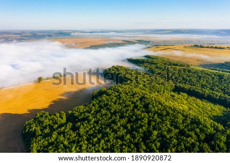 Captivating misty view of green rural land from a bird's eye view. Location place Dniester canyon of Ukraine, Europe. Aerial photography, drone shot. Photo wallpaper. Discover the beauty of earth.
