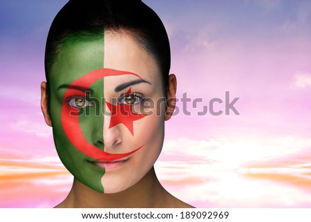 Composite image of beautiful brunette in algeria facepaint against beautiful blue and yellow sky