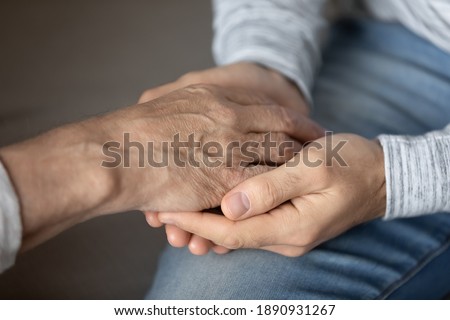 Crop close up of elderly father and adult son hold touch hands showing love and care in family relations. Loving man support comfort stressed unhappy mature dad, feel grateful and thankful. Royalty-Free Stock Photo #1890931267