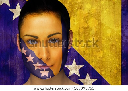 Composite image of beautiful football fan in face paint against bosnia flag in grunge effect