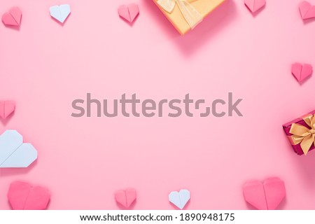Valentine’s Day concept, Red heart with yellow gift box on pink background.