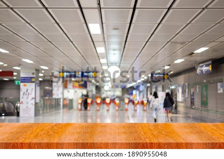 Brown wooden shelves with blurred subway station background.