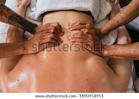 Stock photo of unrecognized person enjoying back massage in spa.