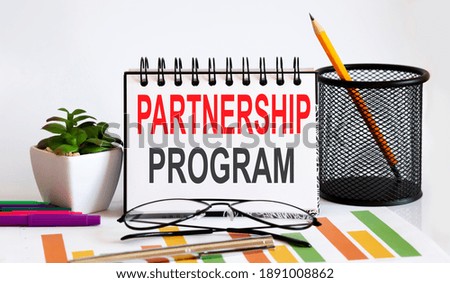 Notebook with Tools and Notes with text PARTNERSHIP PROGRAM business