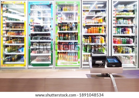 Look out from the payment counter, blur image of a beverage cooler in a convenience store as background. Royalty-Free Stock Photo #1891048534