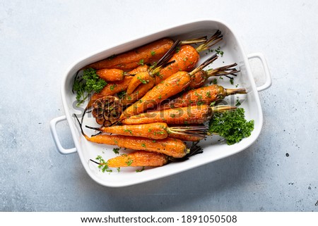 baked carrots in a ceramic form on a light blue background, top view